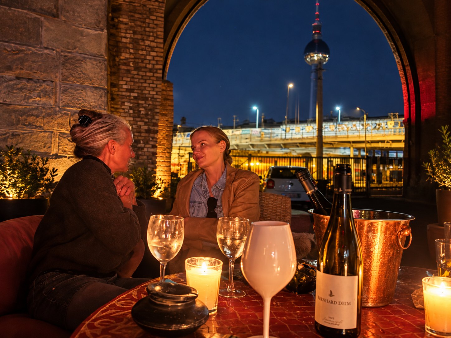 Chez Christine 1190 – Terrasse bei Abendlicht mit gedecktem Tisch und Blick über die Stadt